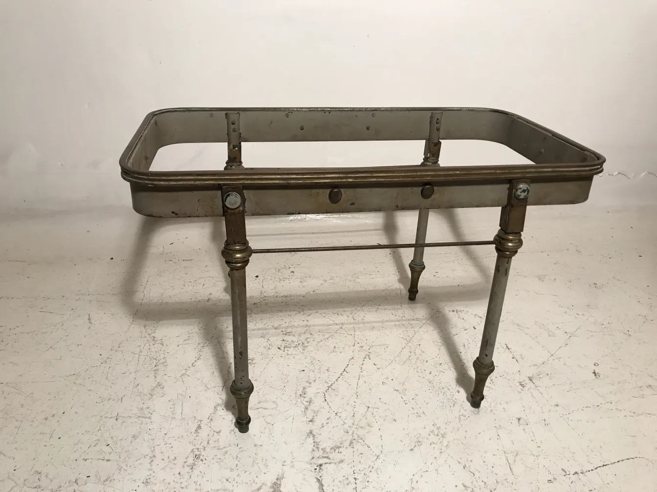 antique garden table with decorative legs and metal frame, in a neutral setting
