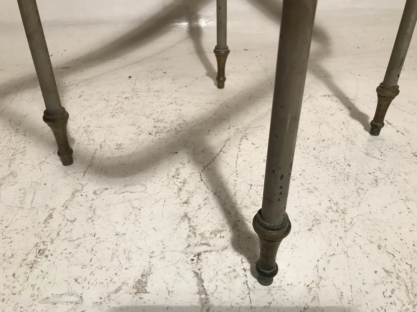 Mesa antiga de jardim com pernas decorativas em um ambiente claro. Ideal para uso ao ar livre.