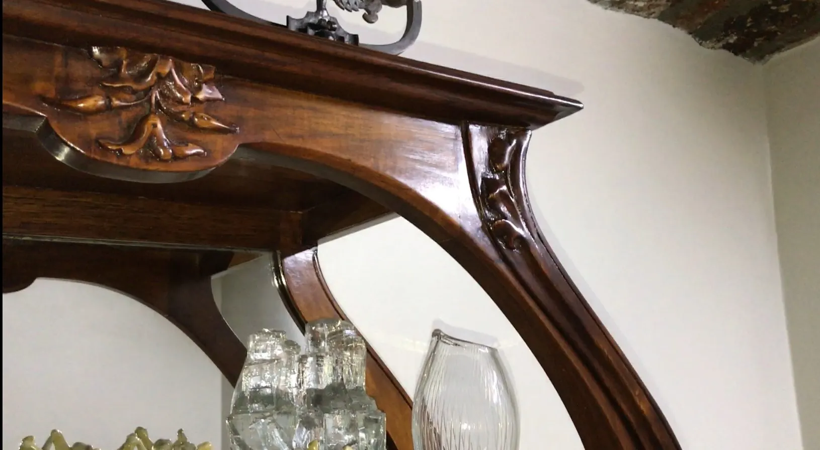 vitrine antiga com curvas elegantes e detalhes no topo, ambiente acolhedor