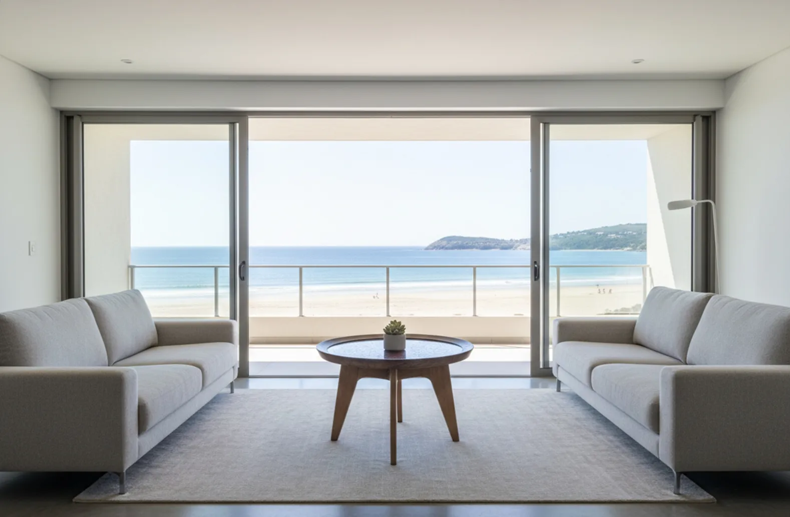 Table basse antique de Charlotte Perriand dans un salon moderne avec vue sur la mer