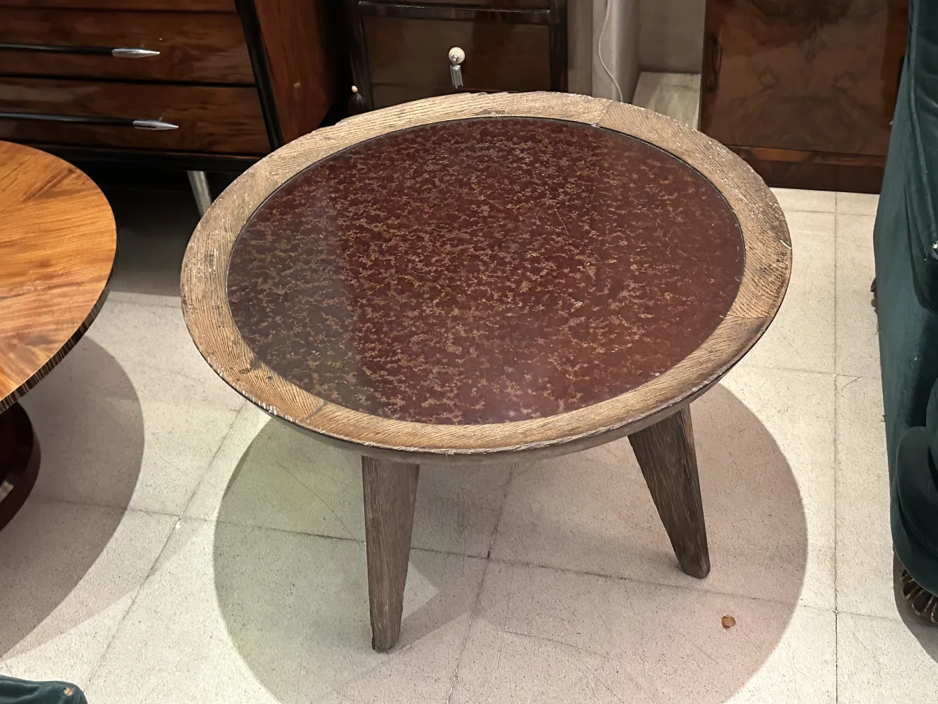 Mesa de centro antiga de Charlotte Perriand com design arredondado e detalhes visíveis, cercada por móveis antigos.