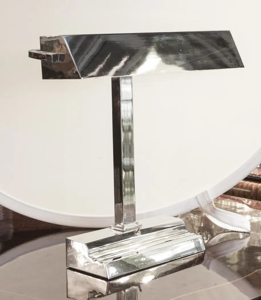 Lámpara de mesa antigua Art Deco con base brillante y diseño elegante en un ambiente moderno.