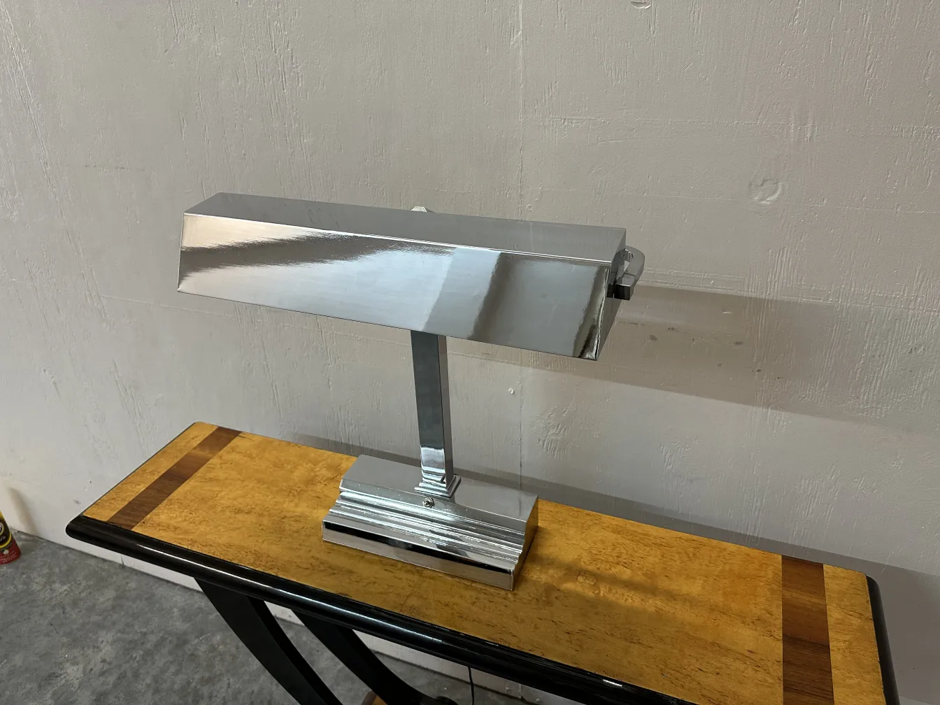 Luminária de mesa antiga Art Deco em uma mesa de madeira clara.