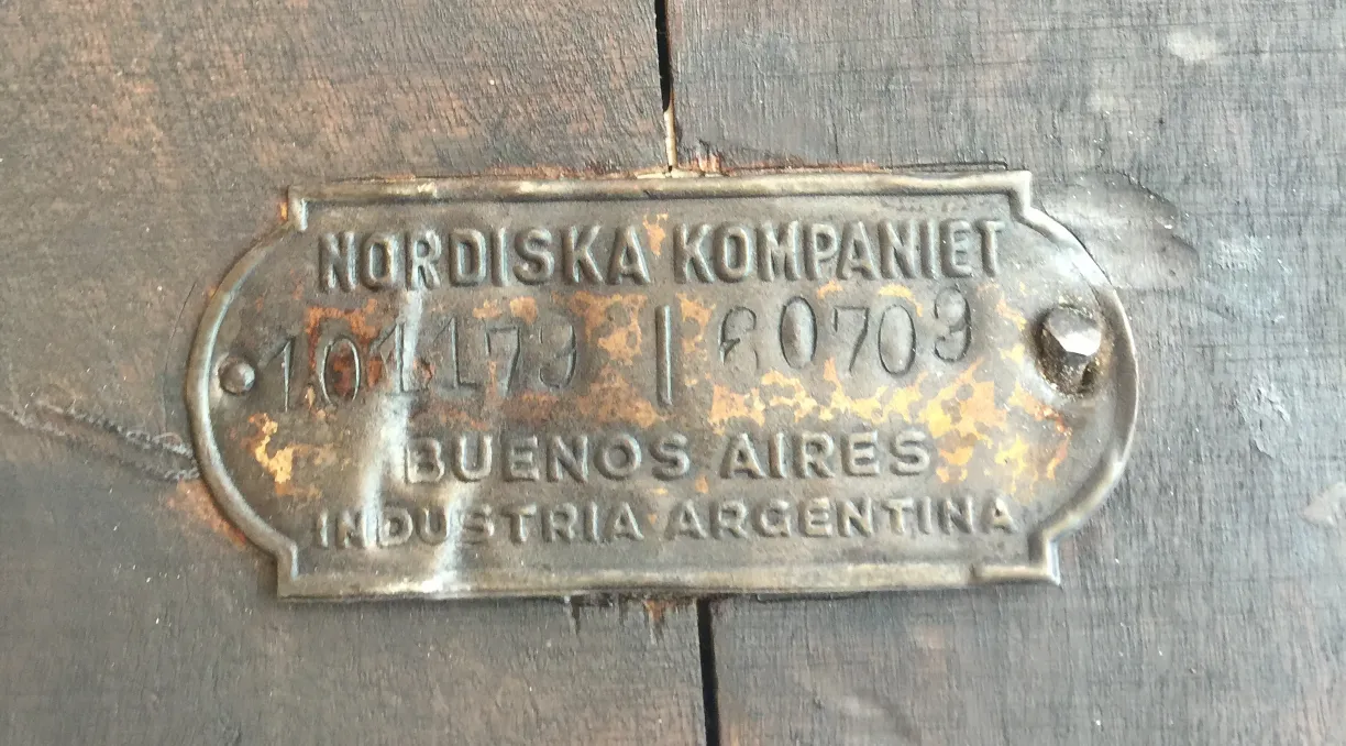 mesa antigua con placa nordiska kompaniet en la superficie