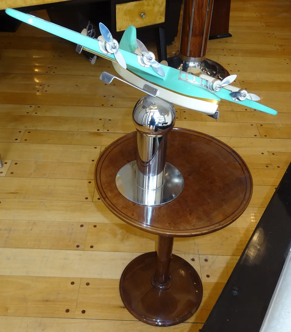 Mesa antiga Nordiska Kompaniet com modelo de avião em cima.