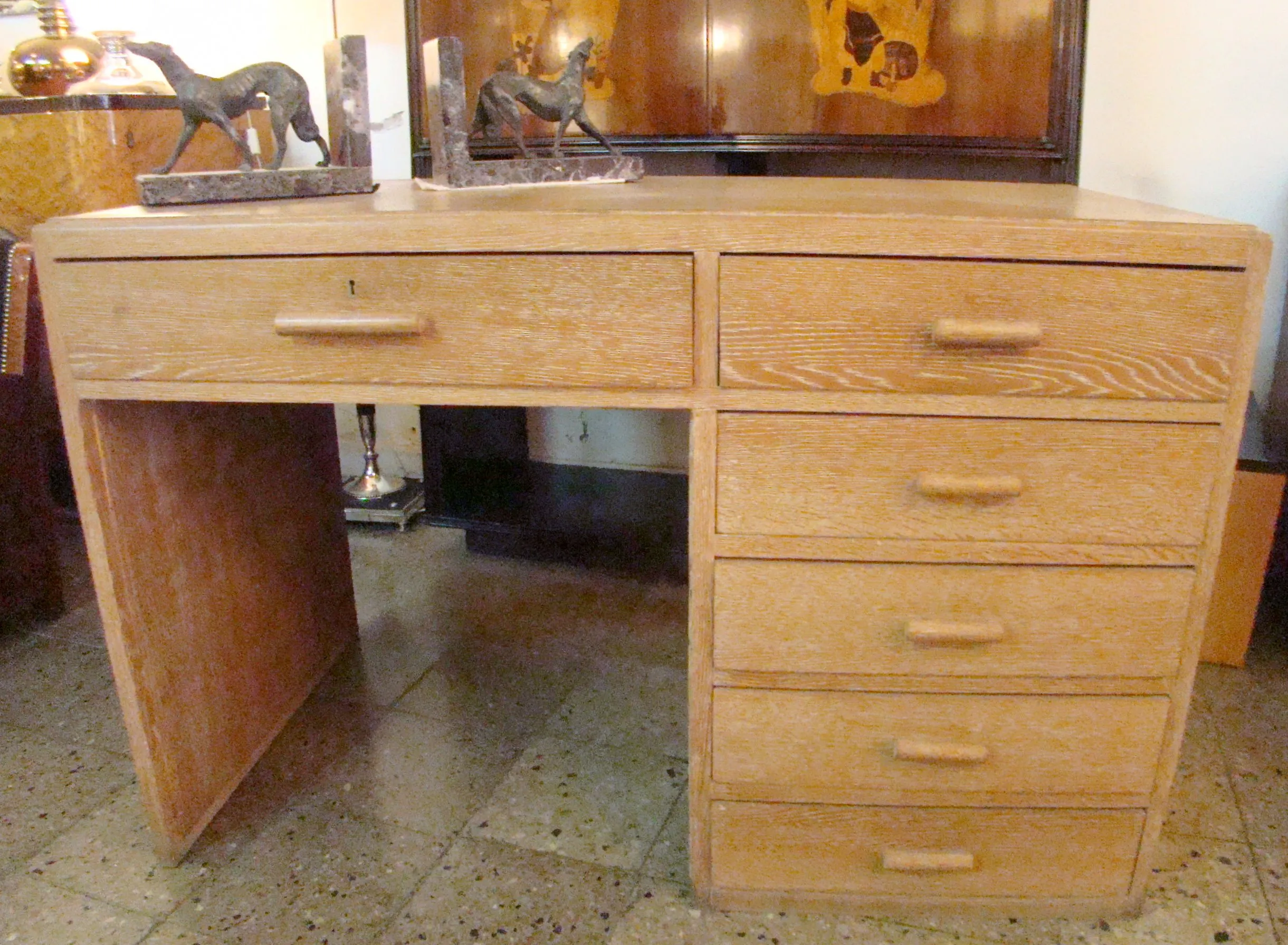 antique desk featuring multiple drawers and decorative figures