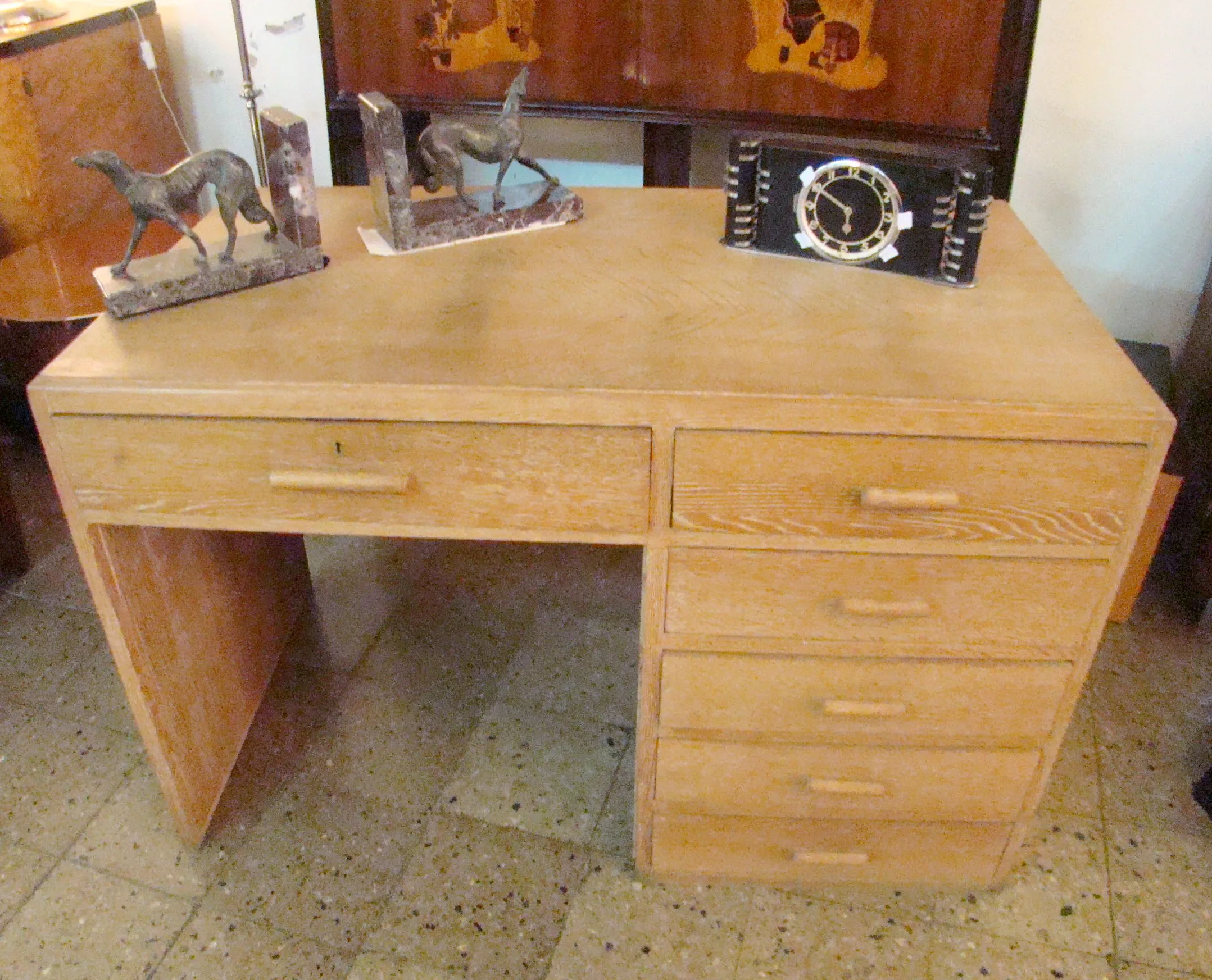 Antik-Schreibtisch mit Regal, dekoriert mit Accessoires. Zwei Hunde-Figuren und eine Tischuhr.