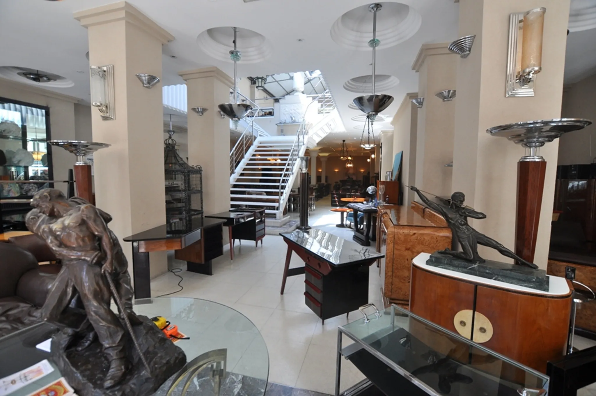 two antique floor lamps in a decorative setting with sculptures