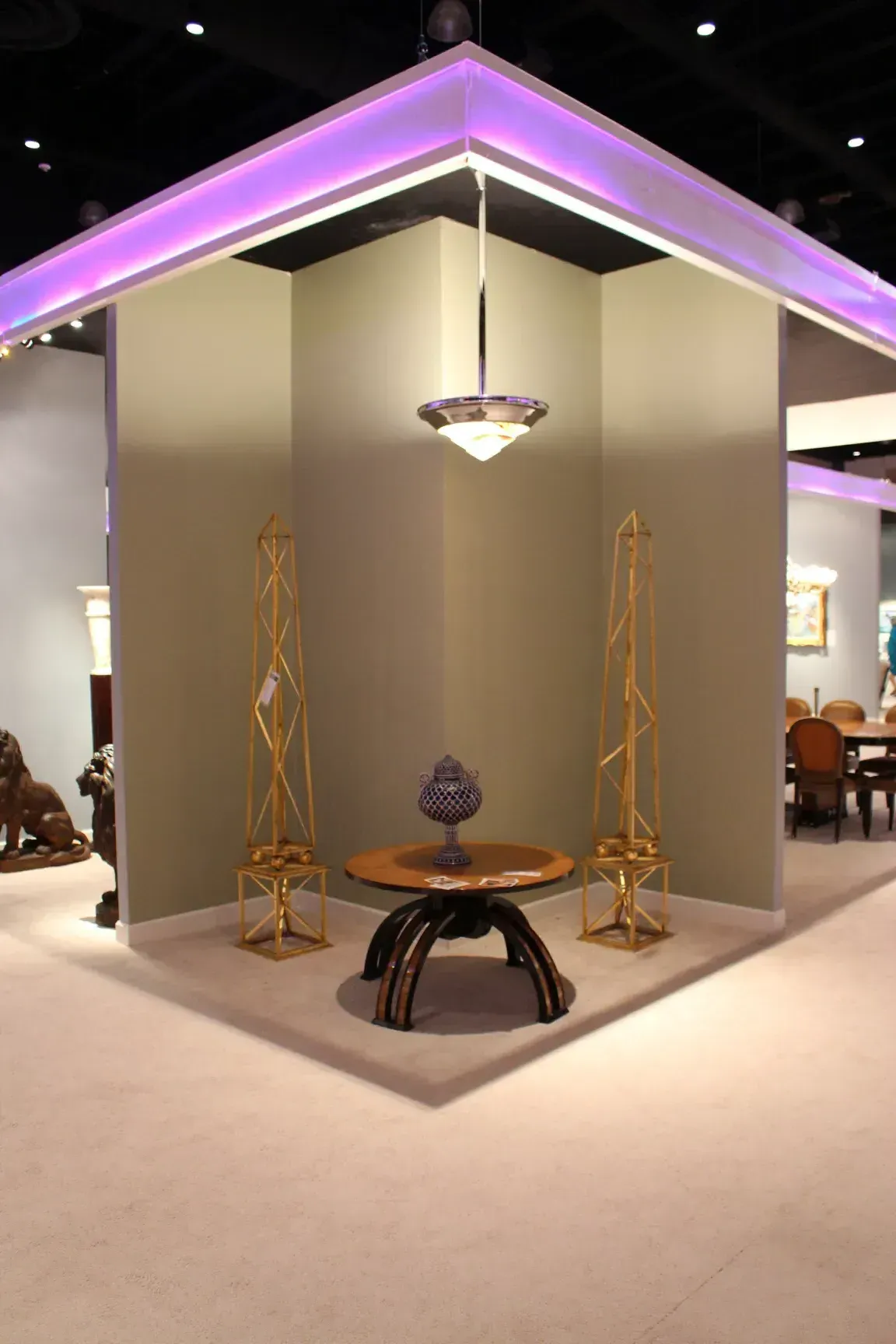 lâmpada de teto antiga iluminando um espaço com mesas e esculturas