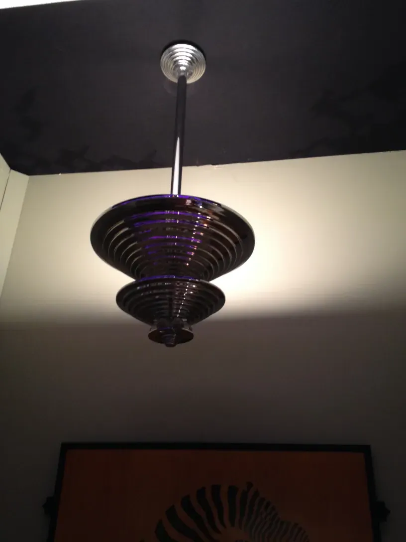 Lámpara de techo antigua con formas esculpidas y luz suave