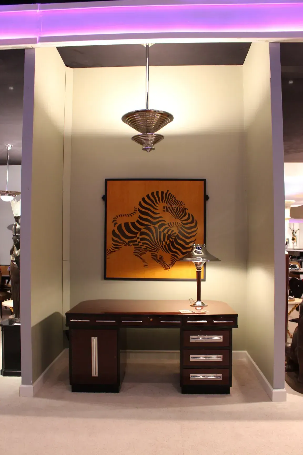 Lampada a sospensione antica con forme art déco, in un ambiente elegante con una scrivania.