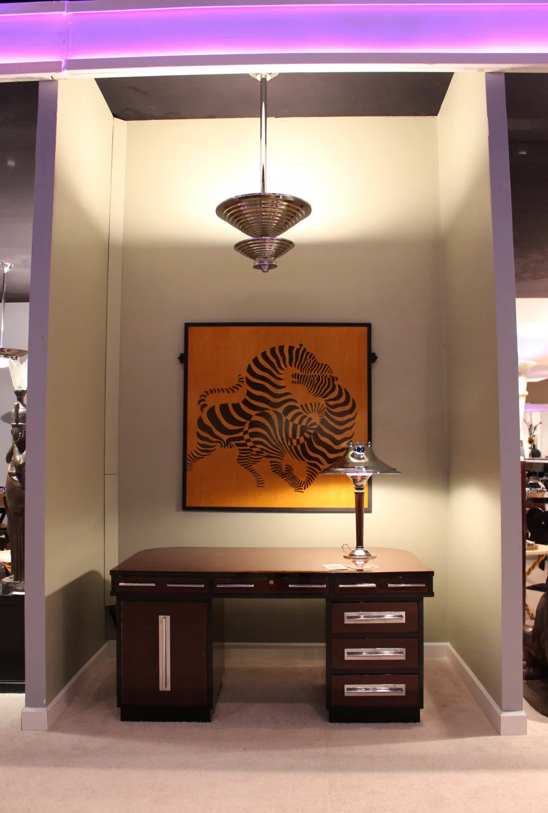 Lámpara de techo antigua de estilo art deco, con un diseño atractivo y una colorida obra de arte en la pared de fondo.