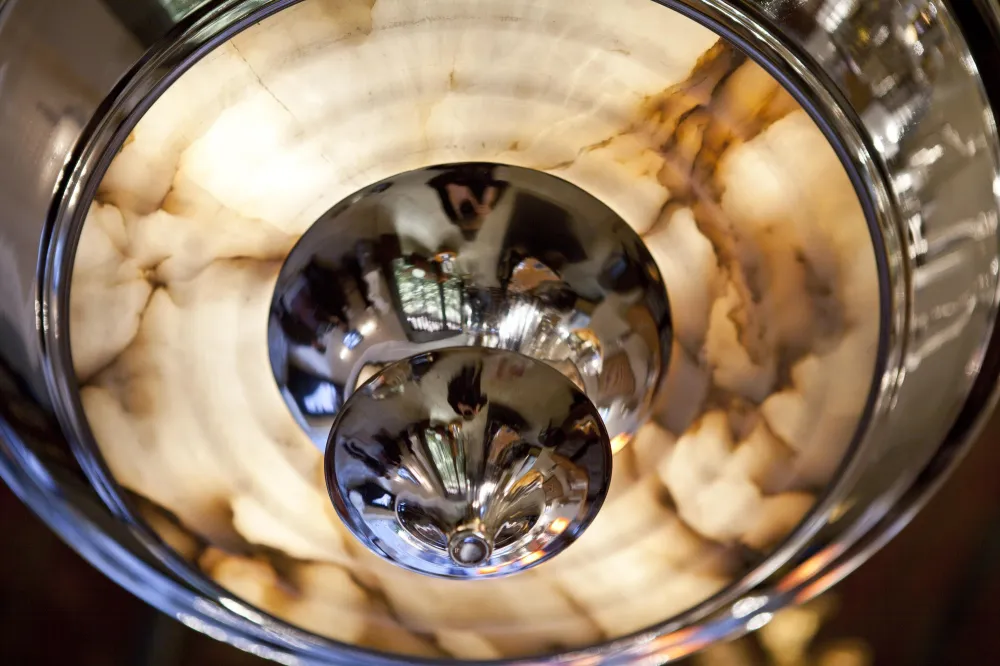 Две антикварные подвесные лампы с дизайном ар-деко, освещающие элегантное пространство.