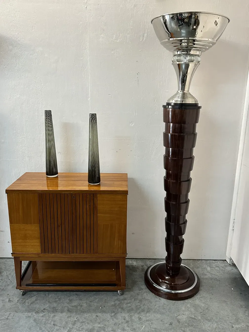 Dos florero antiguo murano con forma elegante y base redonda, cerca de una mesa de madera.