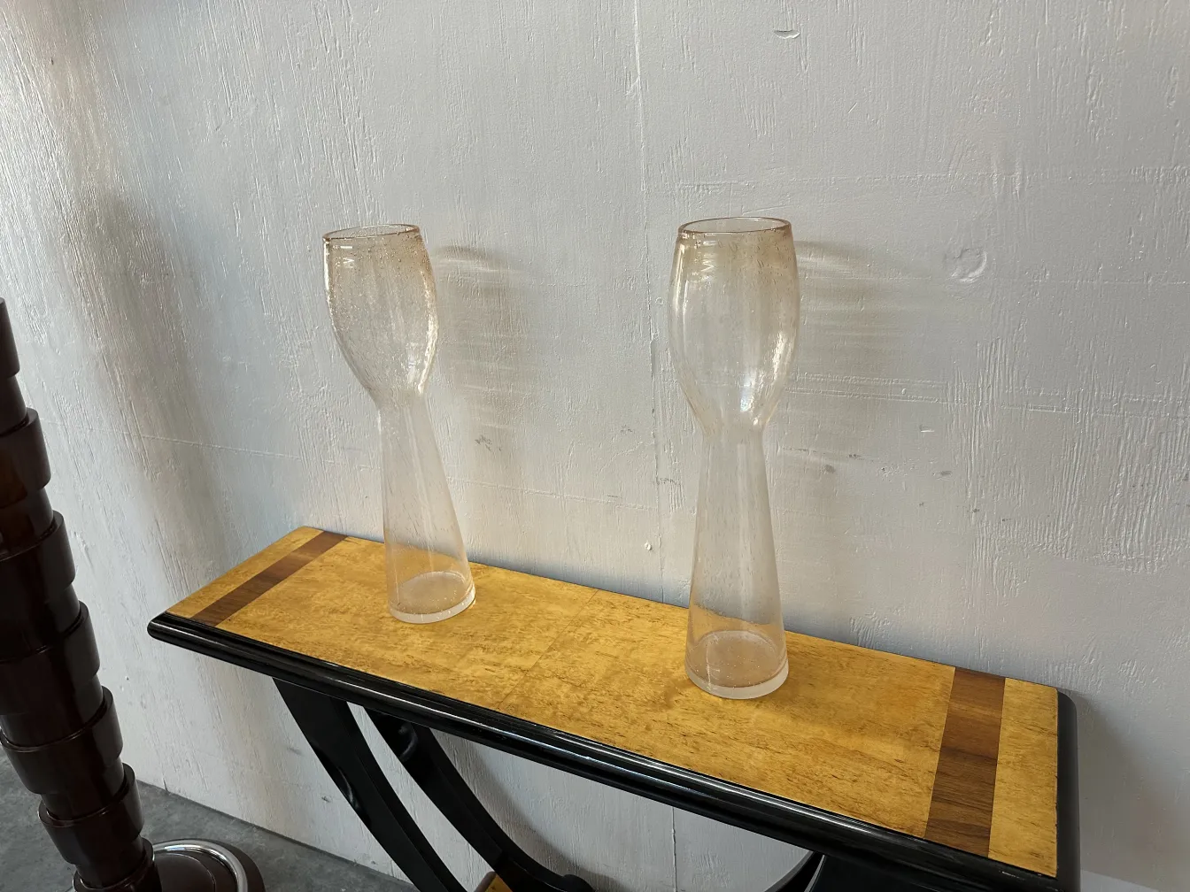 Dois vasos antigos de Murano em uma mesa elegante.