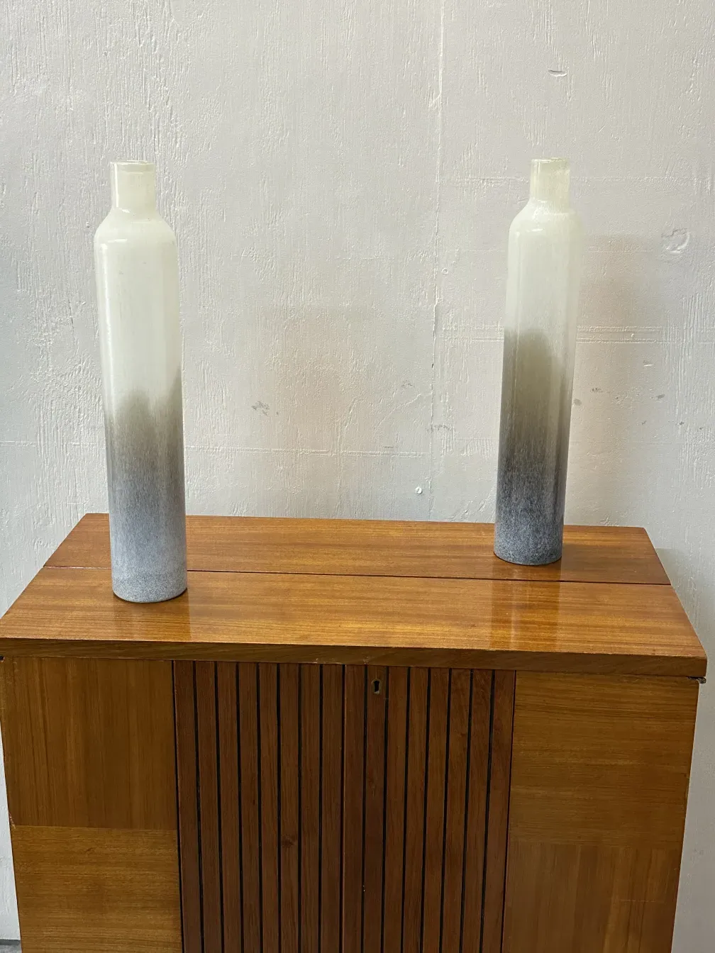 Deux vases anciens avec un design unique, placés dans un environnement chaleureux.