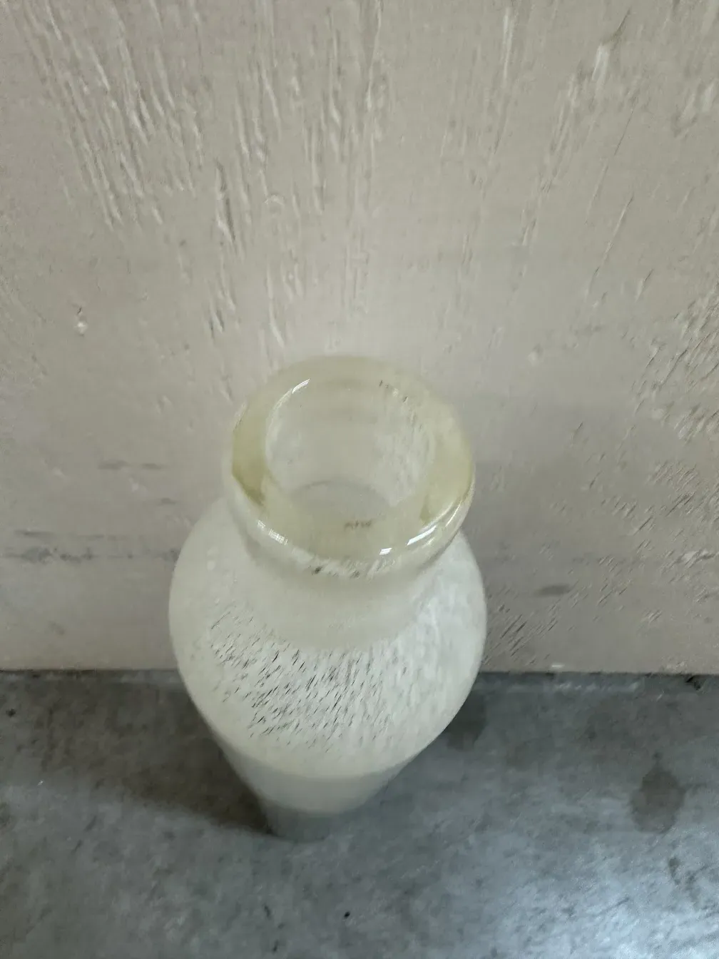 Dos floreros en estilo antiguo de Murano con formas elegantes, uno es más alto. Madera y pared gris de fondo.