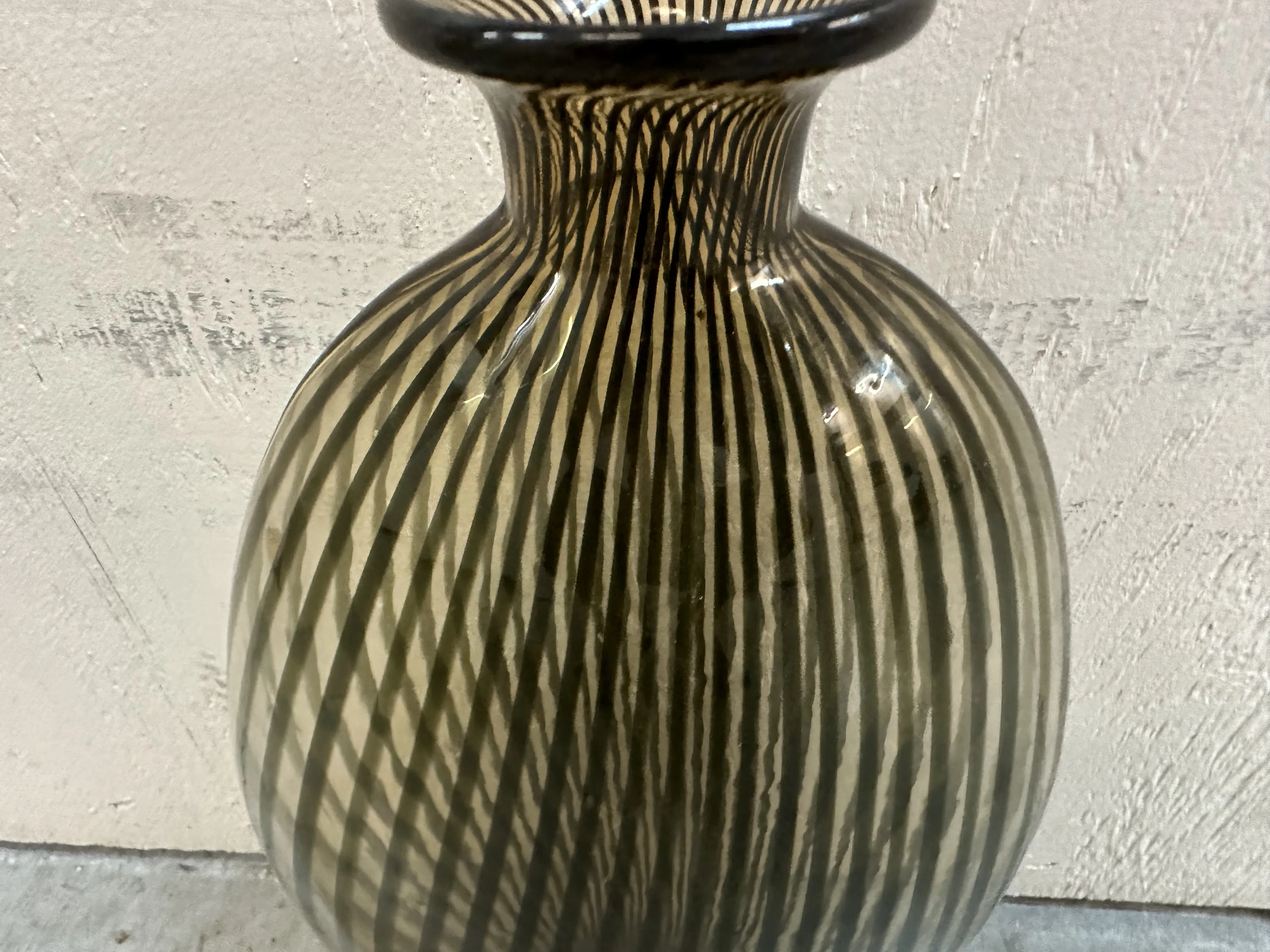 antique vase decorated with stripes in a dark tone