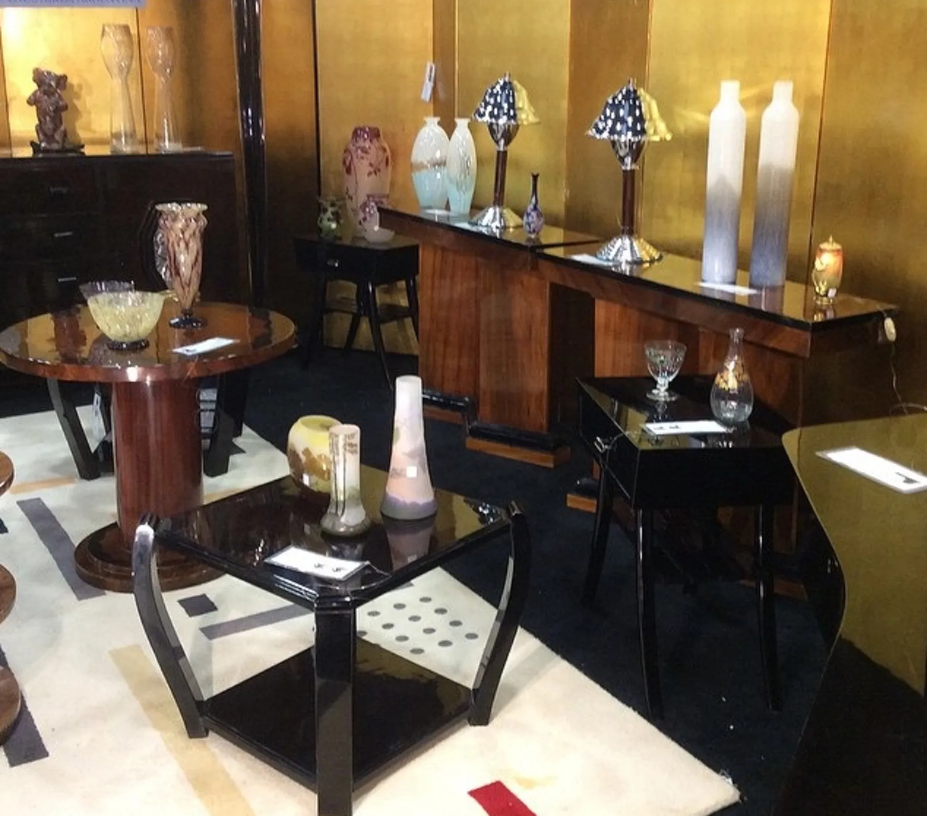 Deux vases de Murano antiques dans un environnement d'exposition avec une table et d'autres objets décoratifs.