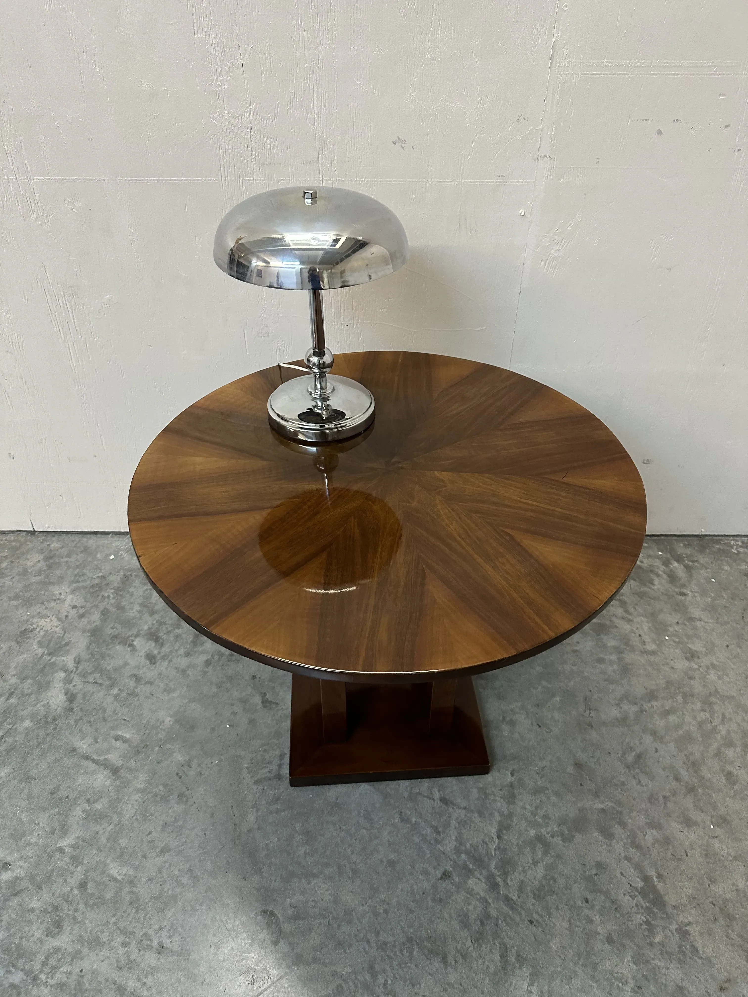 Lampada da tavolo antica su un tavolo rotondo in un ambiente semplice.