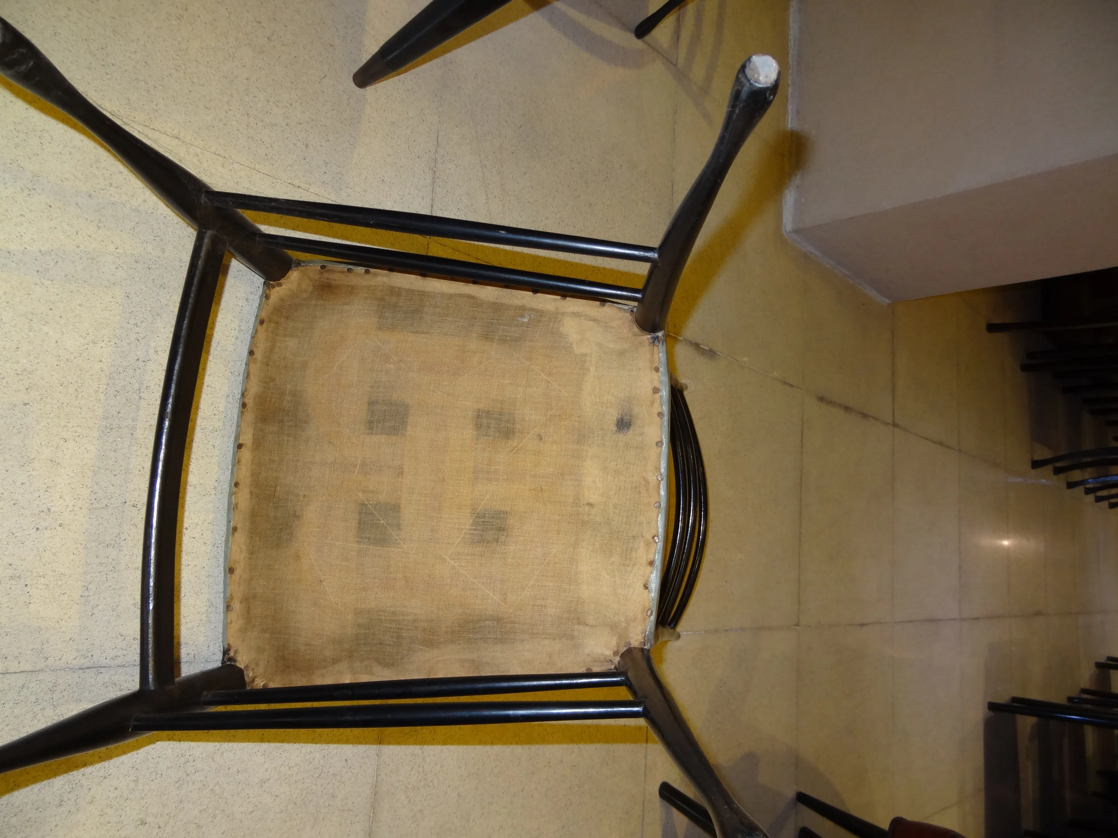 Vista inferior de una mesa de comedor antigua de 8 personas, ambiente con sillas.