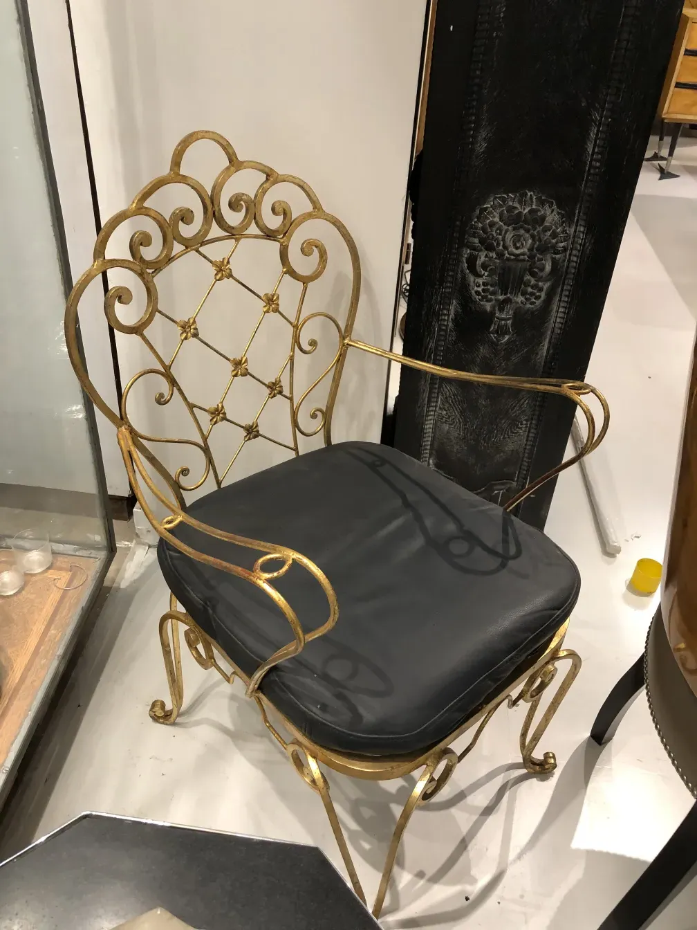 Zwei antike Garten-Sessel im Art Deco-Stil, mit goldenen Akzenten und dunklen Kissen, in einer abwechslungsreichen Umgebung.