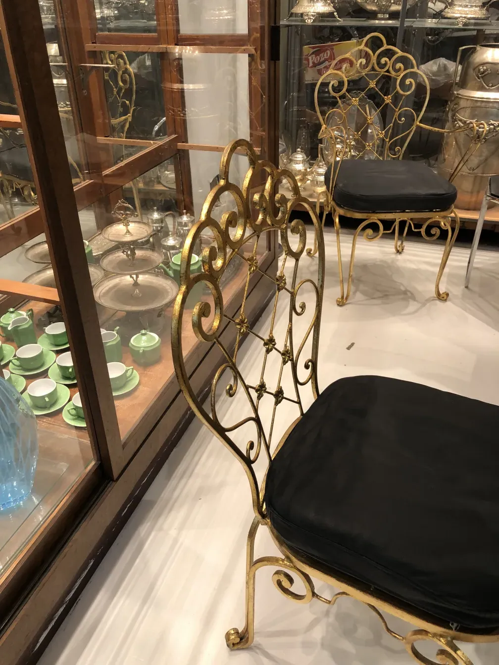 Set of 2 antique garden chairs with decorative design, in an elegant setting.