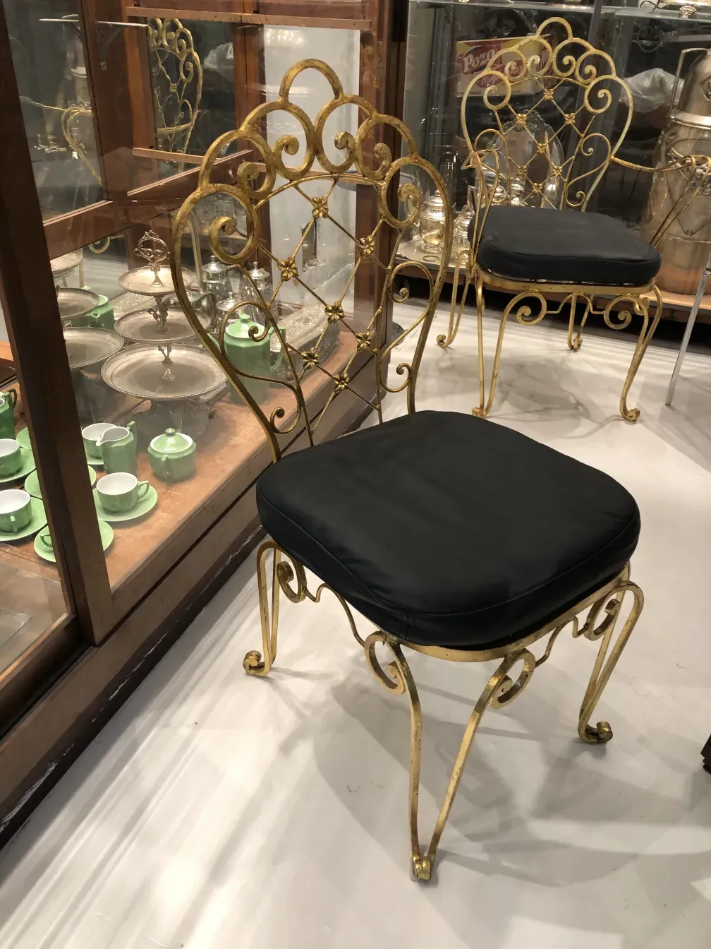 古いガーデンチェア2脚、金色のフレームと暗い座席、ビンテージの環境に配置されています。