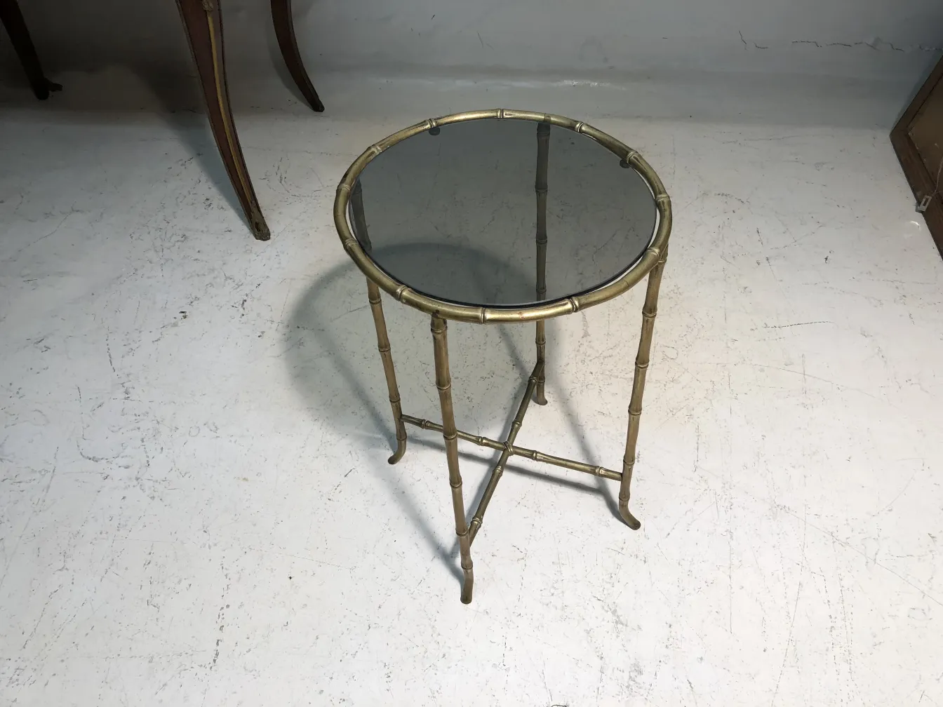 Petite table antique Maison Bagues avec design circulaire et pieds décoratifs.