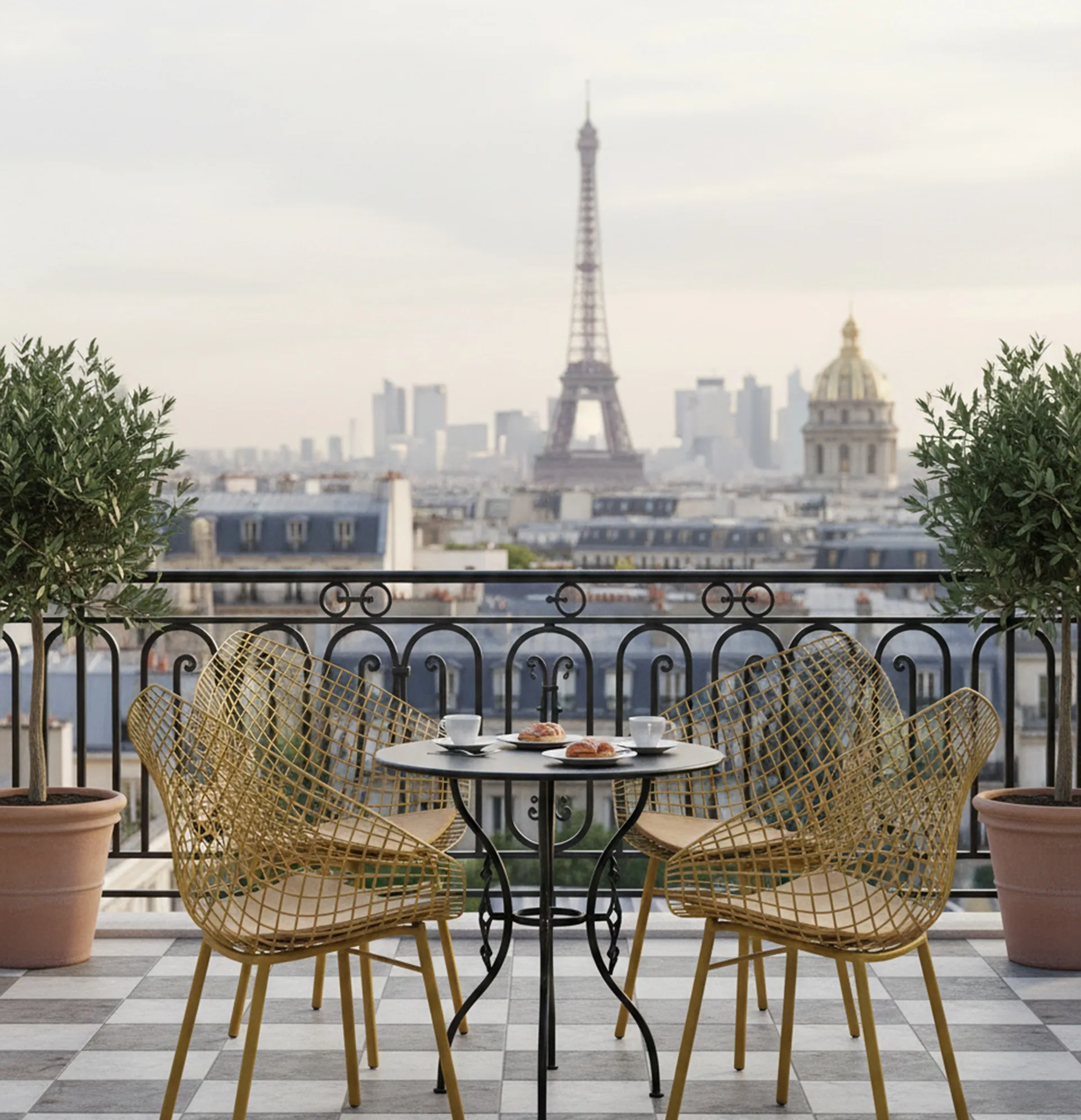 Three antique garden armchairs on a balcony with a Paris view.