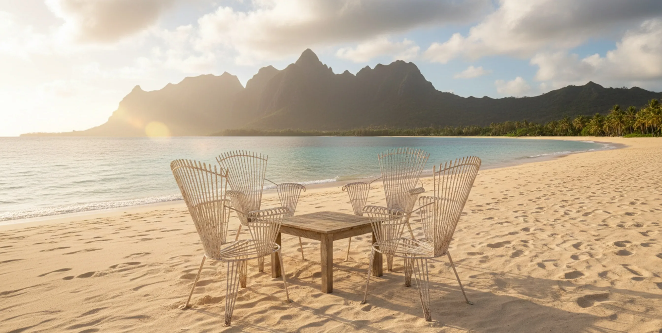Quatre fauteuils de jardin anciens entourés de sable et de mer