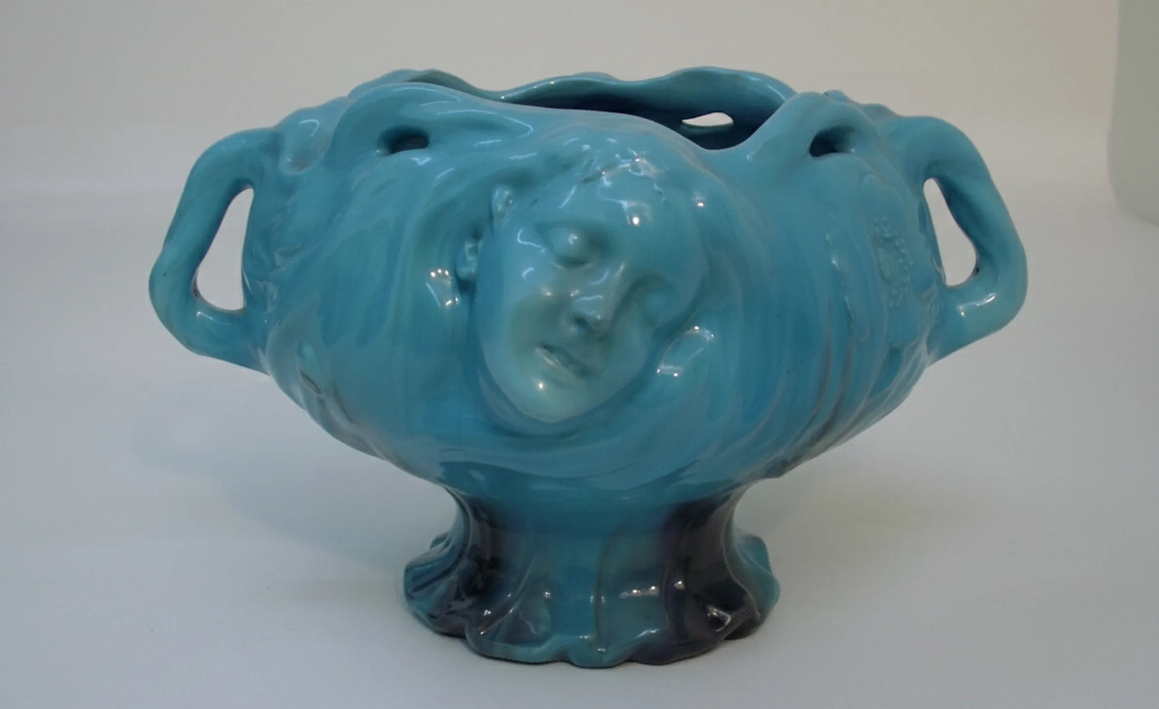 antique ceramic planter in turquoise with decorative face