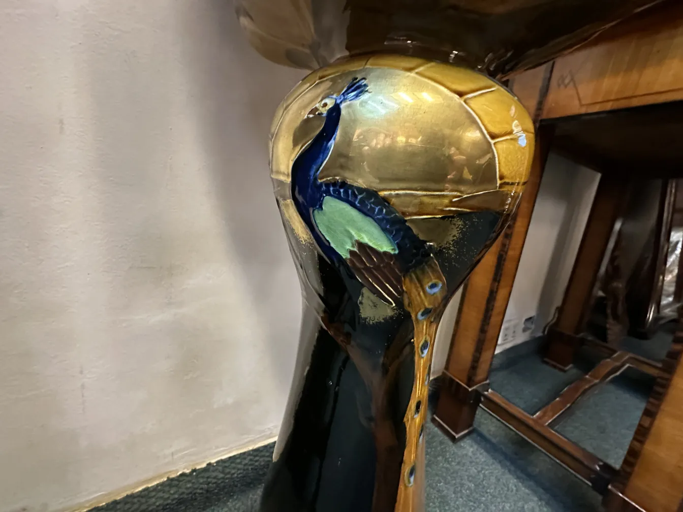 antique planter embellished with an elegant peacock design, decorated in gold and blue tones.