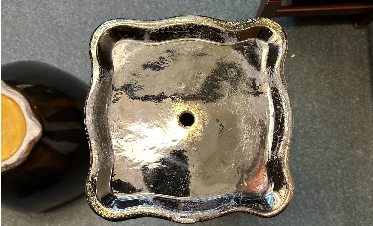 macetero antiguo con forma ondulada, acabado brillante, decorativo