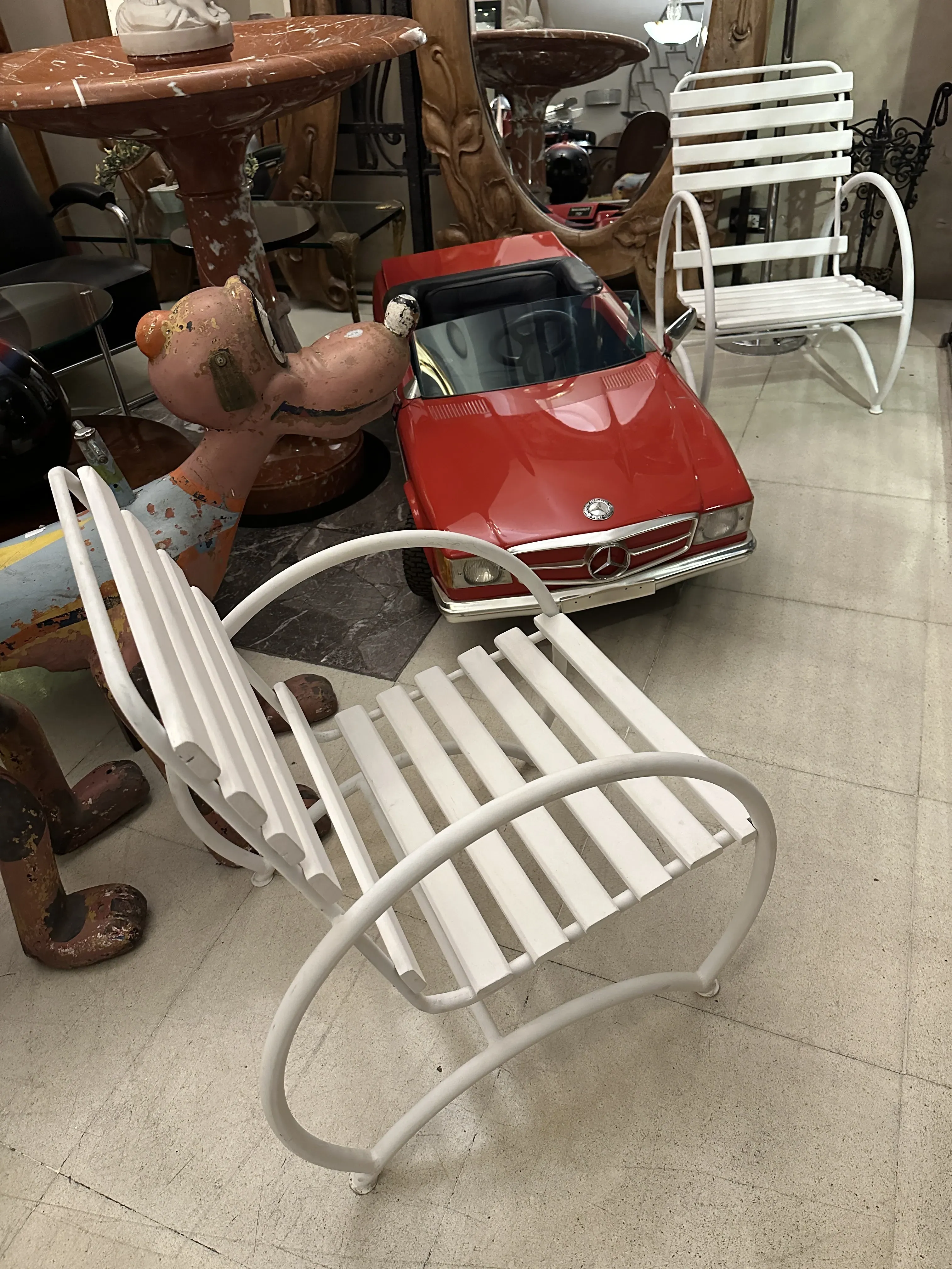 Vue de deux fauteuils de jardin anciens blancs dans un cadre décoratif