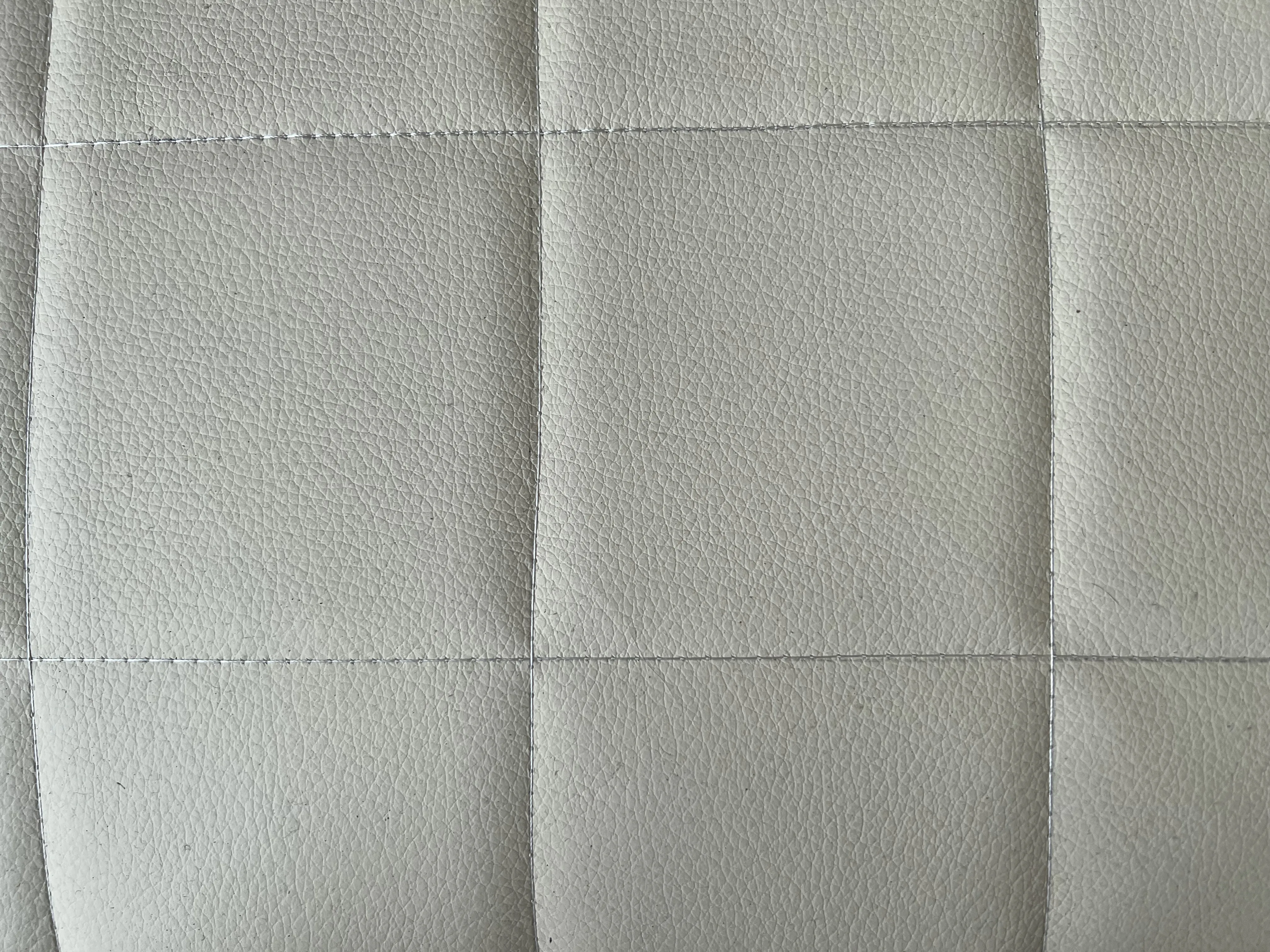 Imagem detalhada de 2 poltronas antigas em cor clara, destacando textura e design.