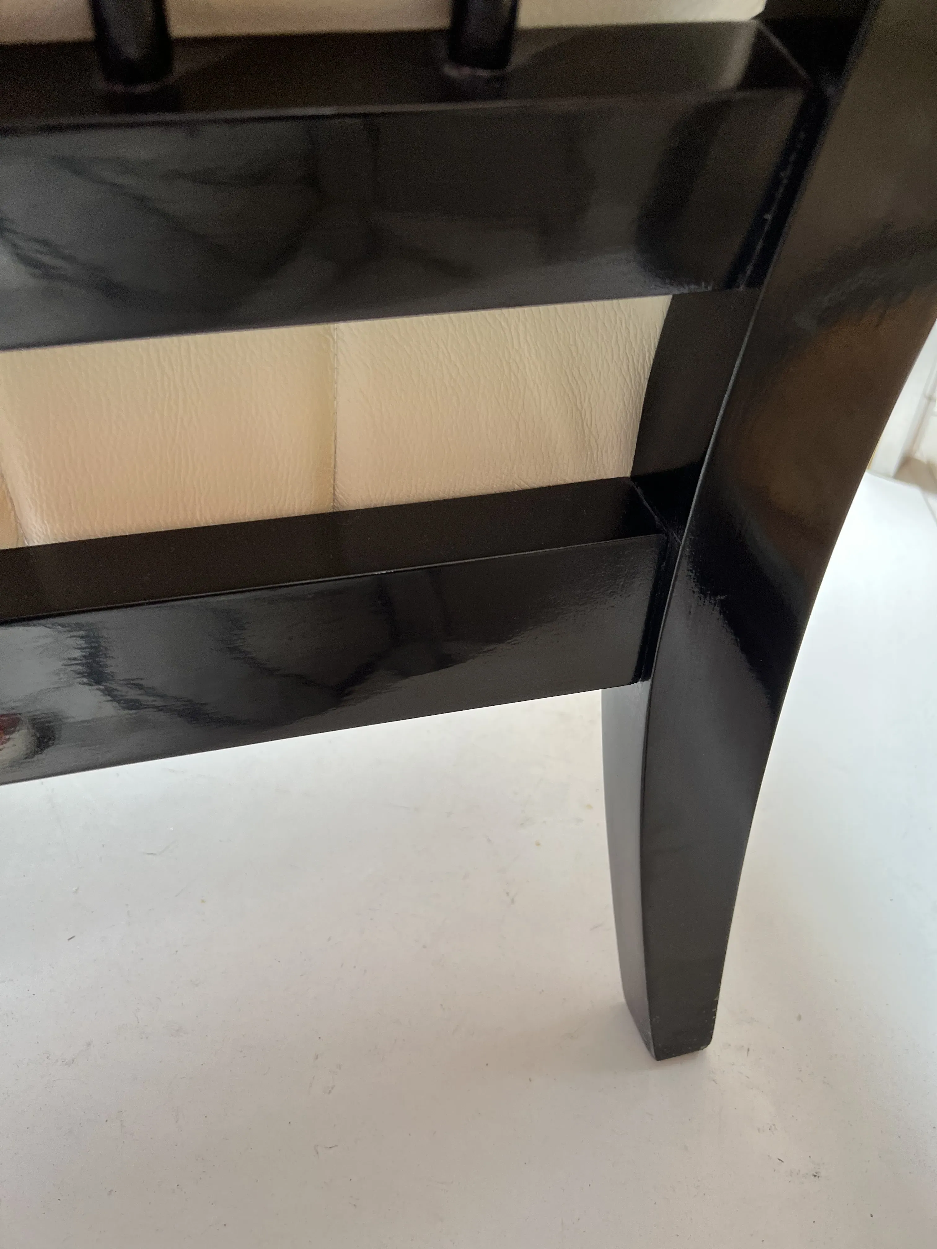 Deux fauteuils anciens de Paolo Buffa avec une structure noire et des coussins clairs, dans un environnement élégant.