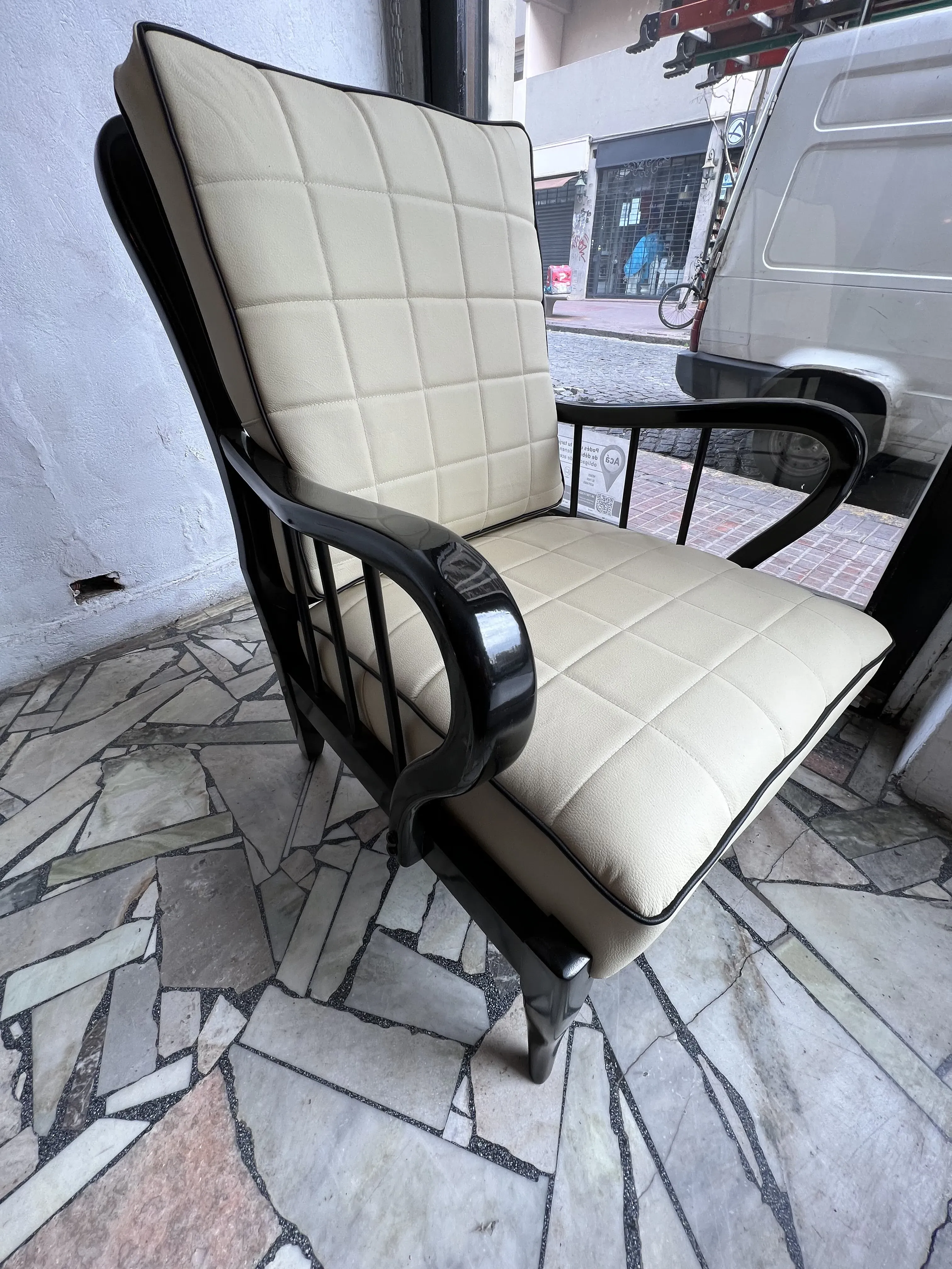 Vue latérale de 2 fauteuils anciens de Paolo Buffa, avec un design classique et une tapisserie claire, arrière-plan urbain