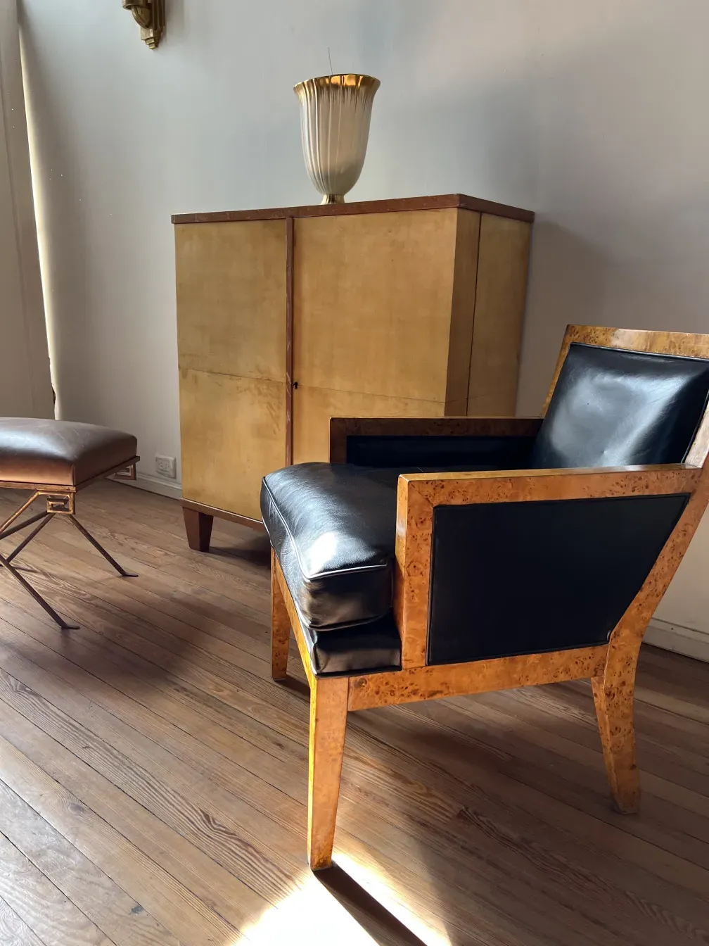 Deux fauteuils antiques avec un design élégant et des détails en bois, dans un environnement chaleureux.