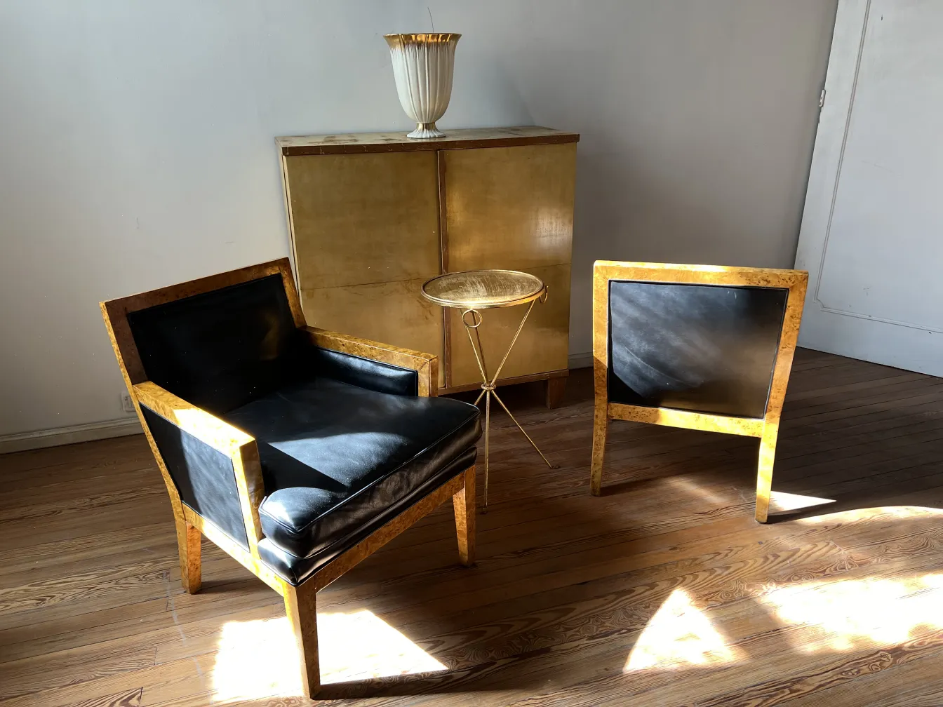 Dos sillones antiguos de diseño distintivo en la sala, uno a un lado y otro en frente del primero, con una mesa dorada en el centro