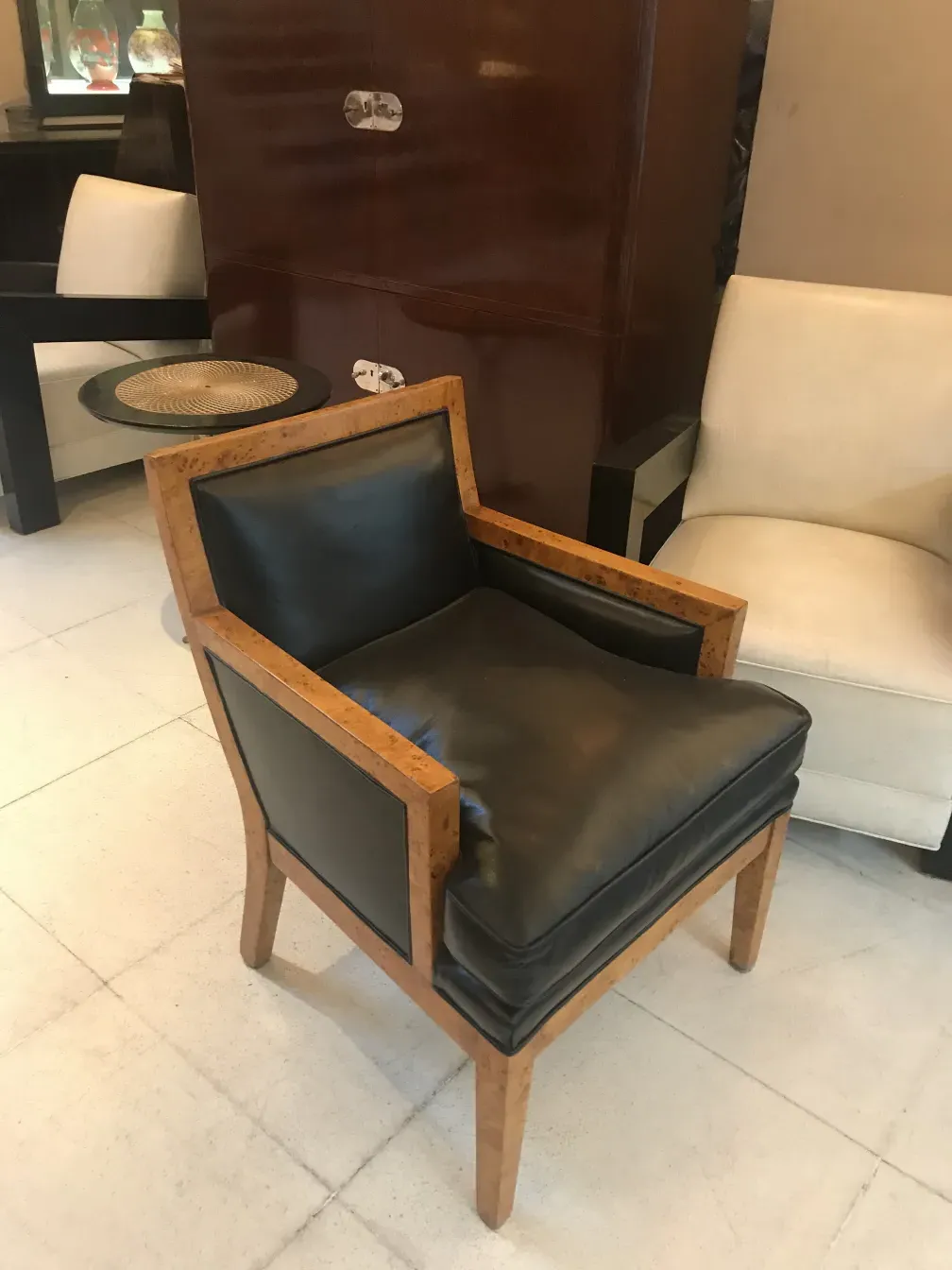 Due poltrone antiche in stile classico, una nera e una bianca in un ambiente elegante.