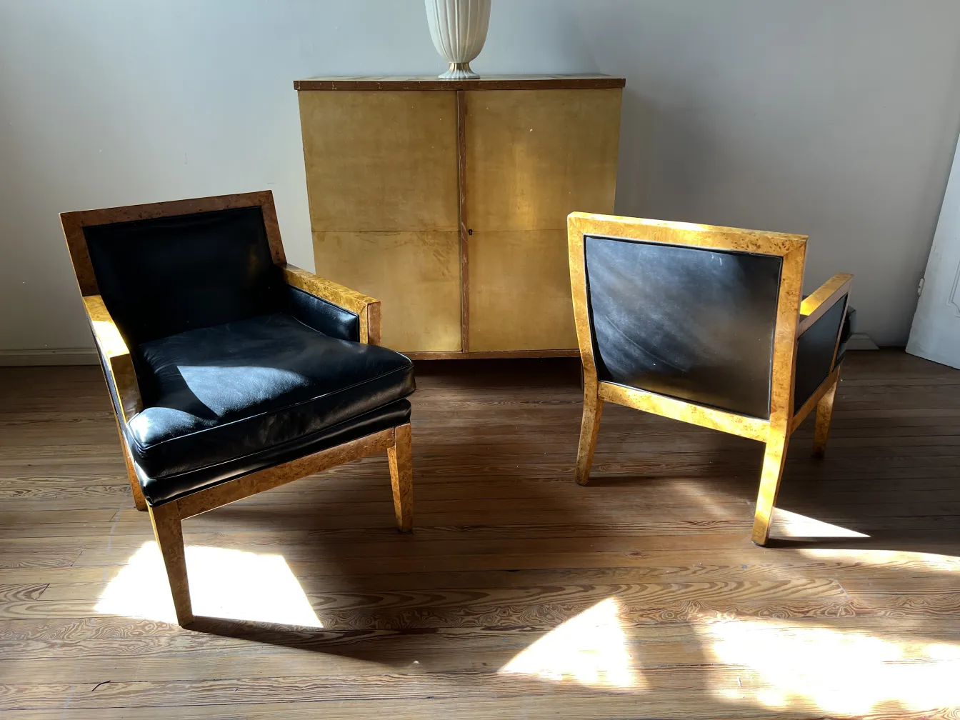 deux fauteuils anciens au design élégant dans un environnement lumineux.