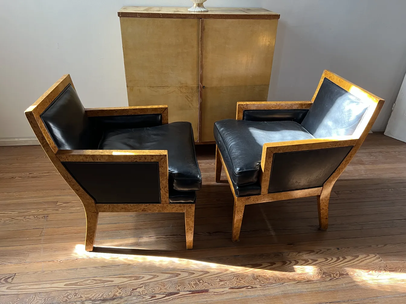 Two antique armchairs by Jean Michel Frank in a cozy setting.