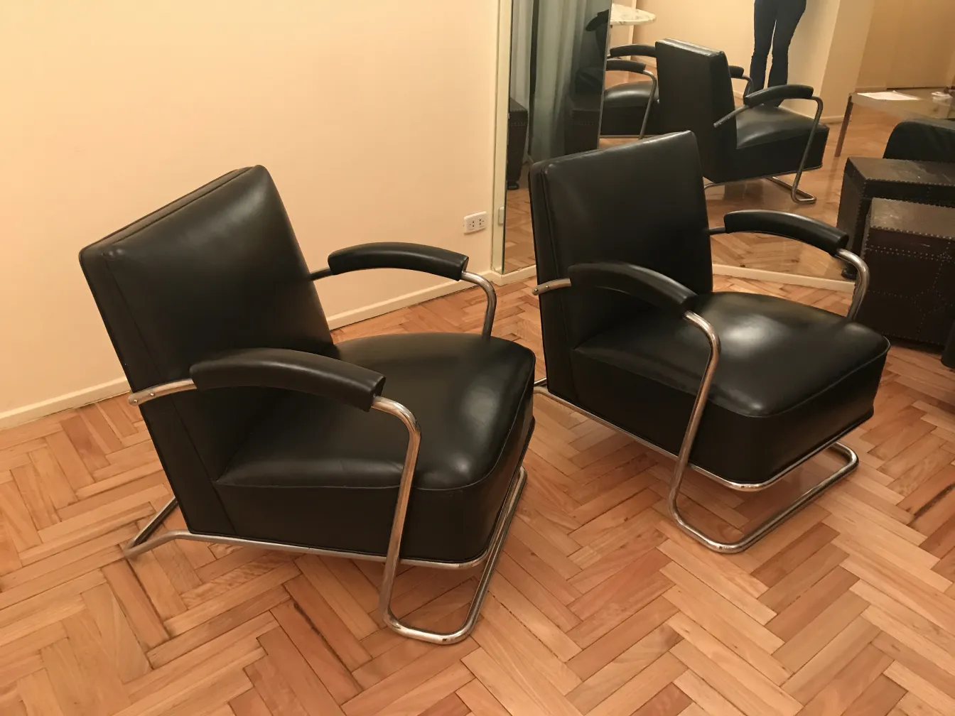 due poltrone antiche art deco con braccioli e base metallica, in un ambiente accogliente