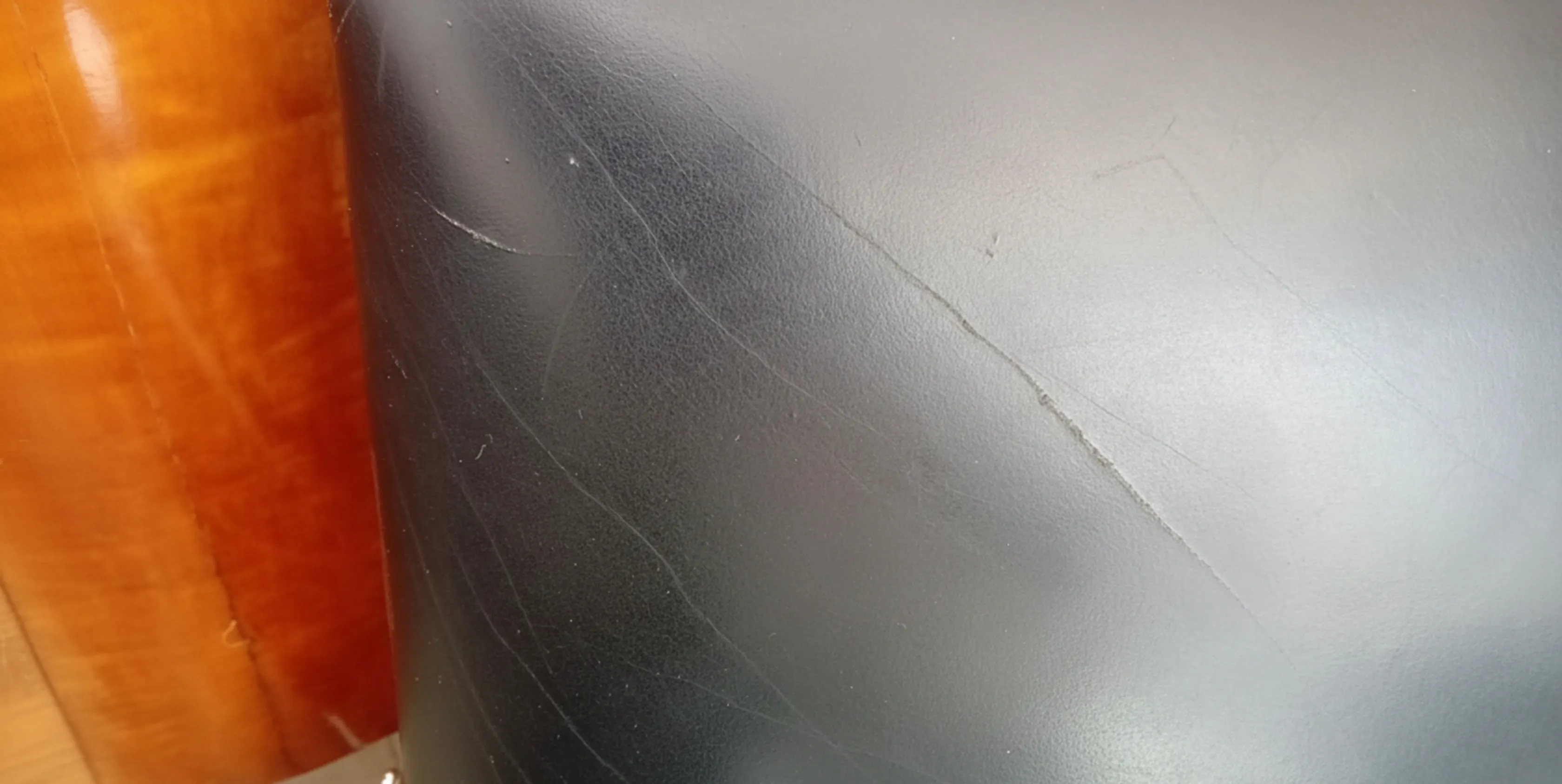 Detalhe de duas poltronas antigas com desgaste visível no revestimento, em um ambiente acolhedor.