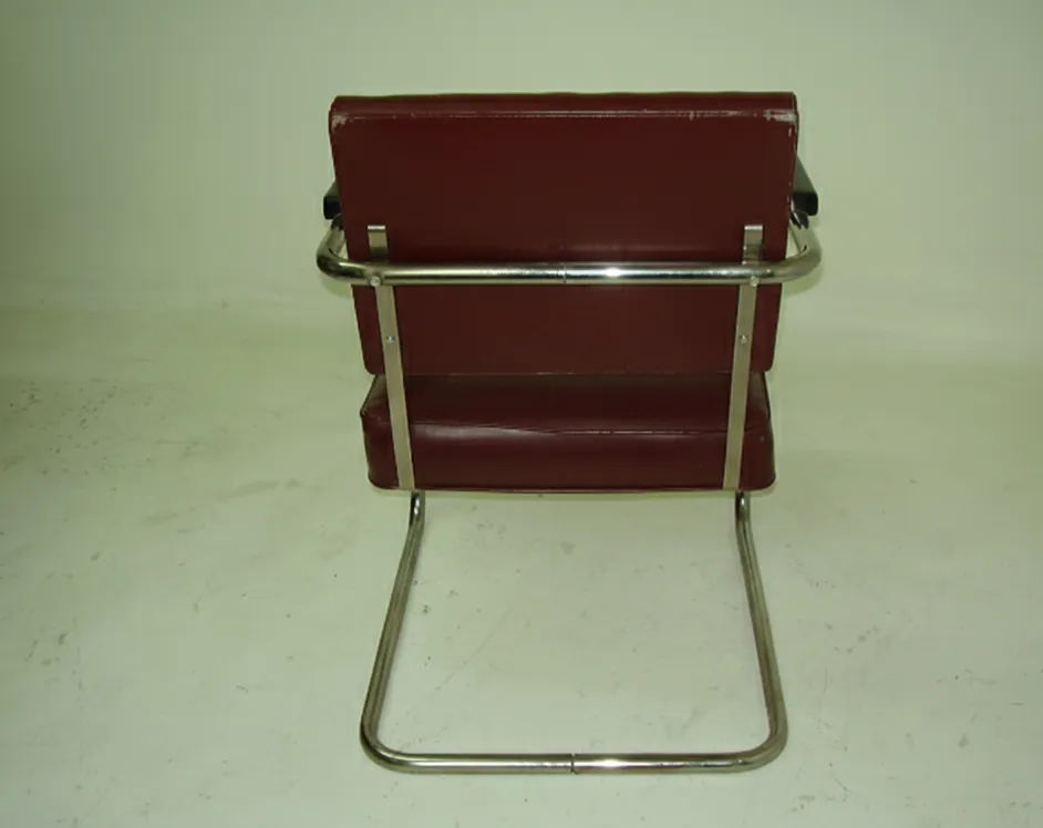 Rear view of two antique armchairs to be restored in a neutral setting.