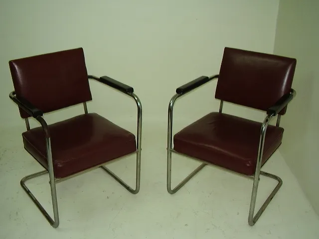 paire de fauteuils à restaurer en marron, avec accoudoirs, dans un cadre neutre.