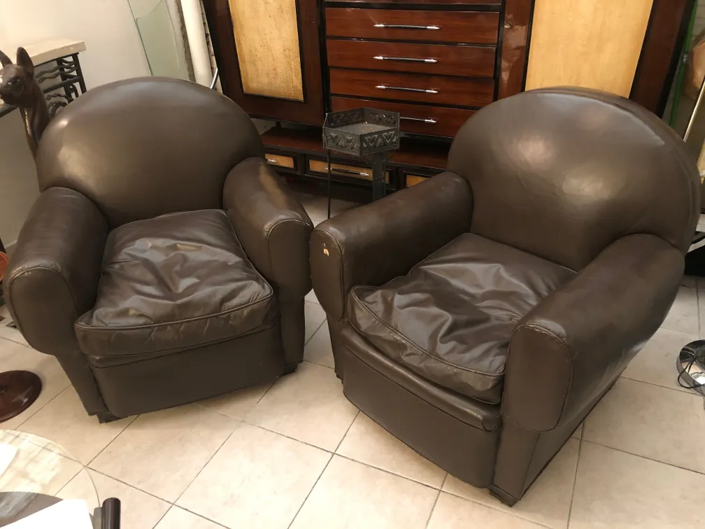 Deux fauteuils anciens à restaurer, avec un design classique dans un cadre chaleureux.