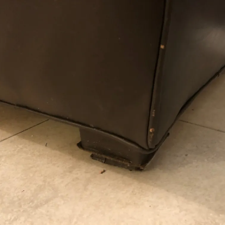 Ansicht eines antiken Sessels mit Abnutzungserscheinungen und unterer Stütze