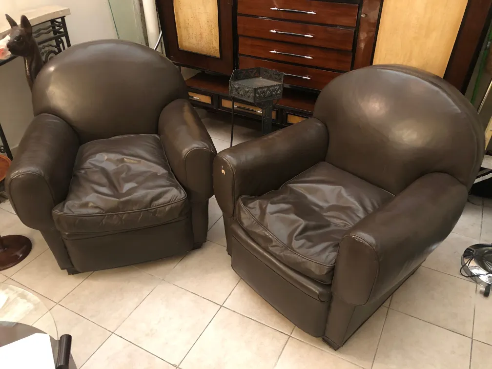 Zwei antike Sessel mit abgerundetem Design in einer eleganten Umgebung.